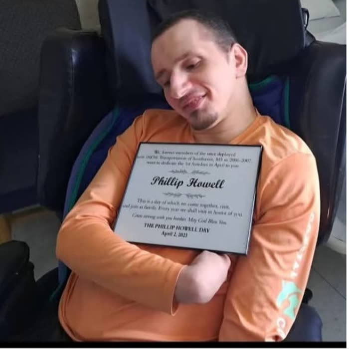 Phillip Howell holding his Phillip Howell Day dedication plaque